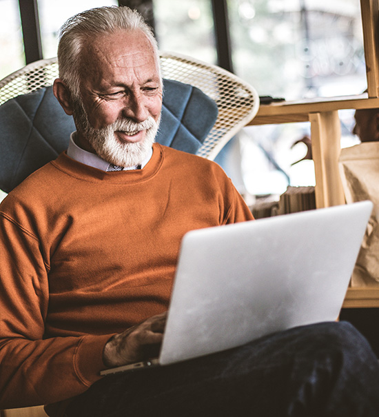 Man working on his laptop while sitting in a chair