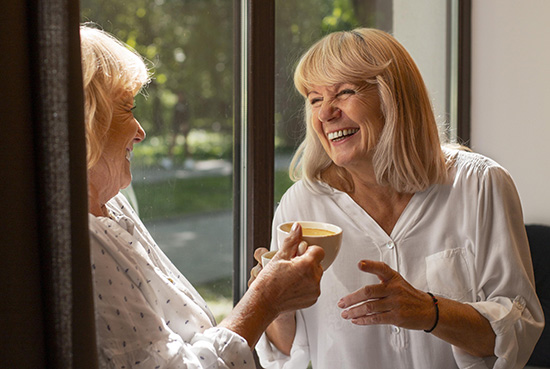 Two women sharing a laugh and a coffee